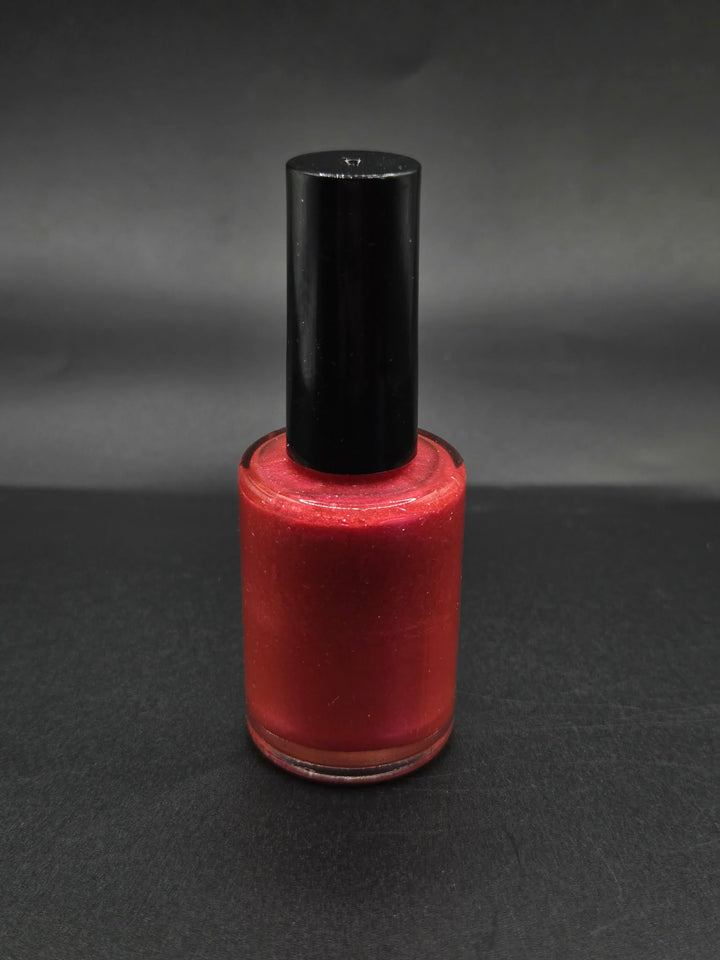 Rich Red by Irilune, red shimmer nail polish in a bottle with a black cap.